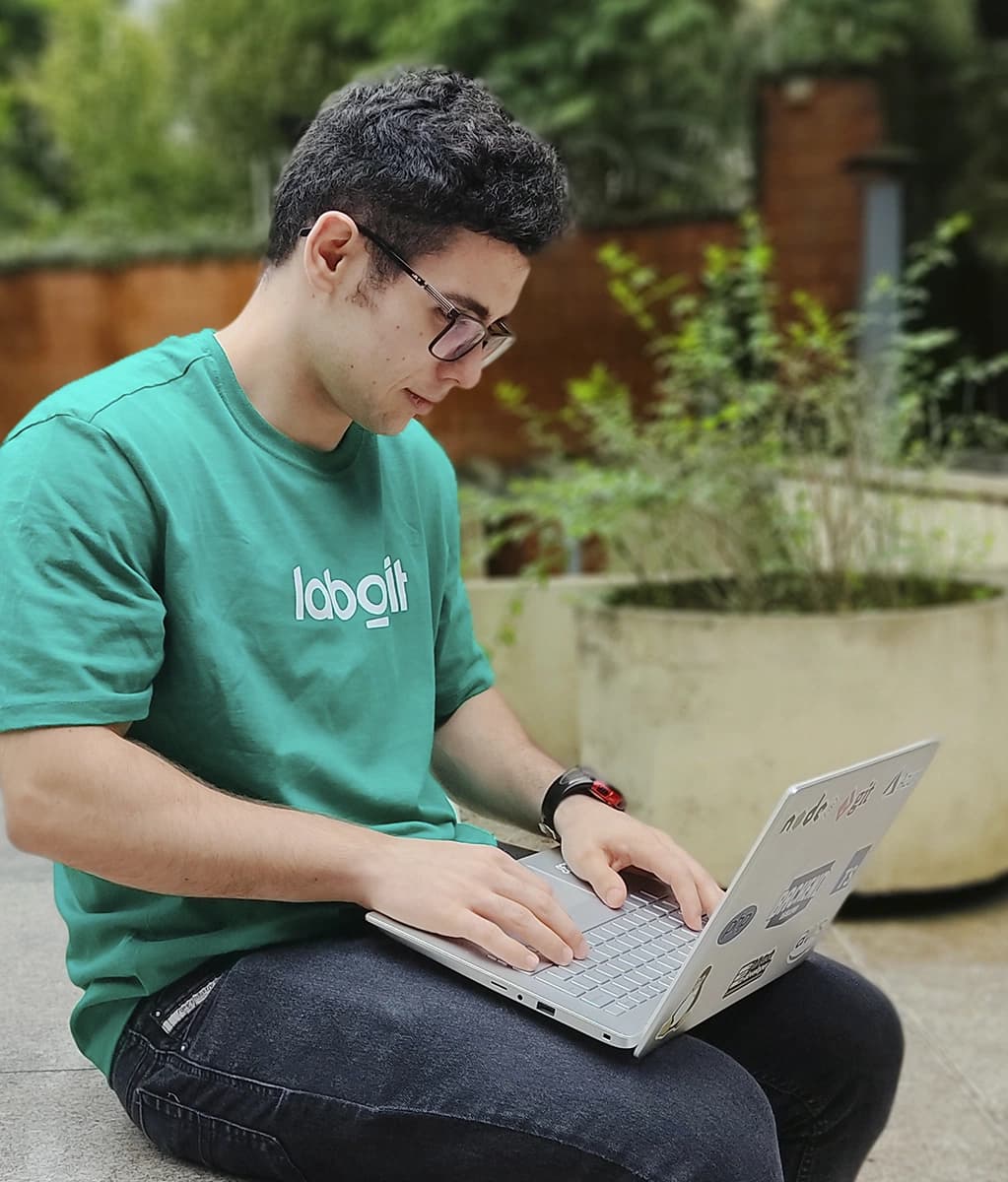 Luis Eduardo, backend engineer at Laborit, working on the outside of our glass house.